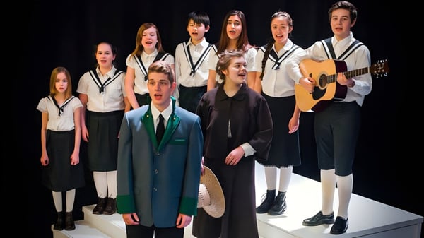 Estudiantes de la Abbotsford School of Integrated Arts están con instrumentos musicales en un escenario durante una actuación.