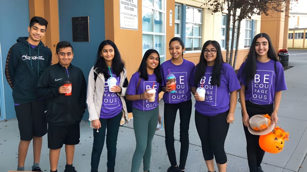 Un grupo de estudiantes frente al colorido edificio de la Abbotsford Traditional Secondary School.
