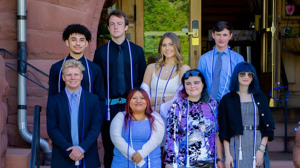 Un grupo de estudiantes está frente a un edificio de ladrillo en el campus de la Accelerated School.