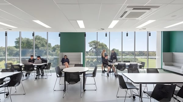 Moderna oficina abierta con grandes ventanas y lugares de trabajo en el campus de la Adelaide High School.