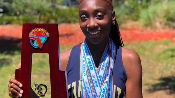 Una persona con ropa tradicional africana está de pie en el área verde de la Admiral Farragut Academy.