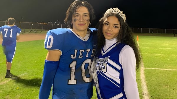 Dos estudiantes están en el campo deportivo del Alameda Unified School District por la noche.