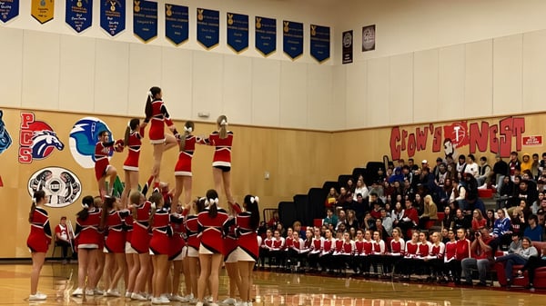 Un grupo de porristas realiza una presentación de baile en el escenario de la Alberni District Secondary School ante un público.