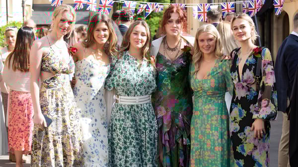 Un grupo de estudiantes de la Aldenham School está frente a una calle con banderas del Union Jack.