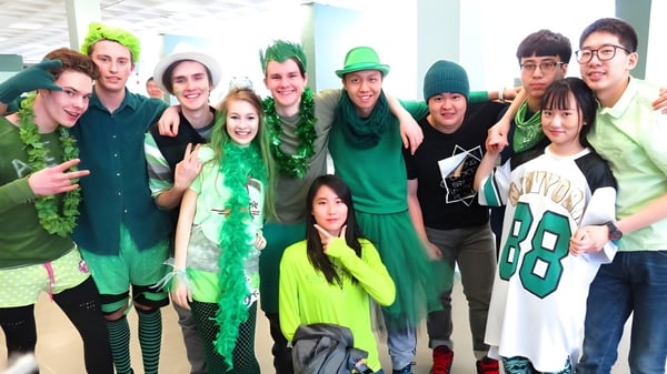 Un grupo de estudiantes de la Alexander Galt Regional High School celebra juntos vestidos de verde y en disfraces.