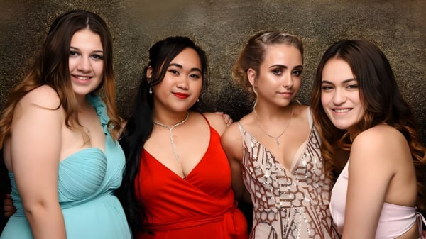 Cuatro estudiantes del Alfriston College posan juntas frente a un fondo dorado.