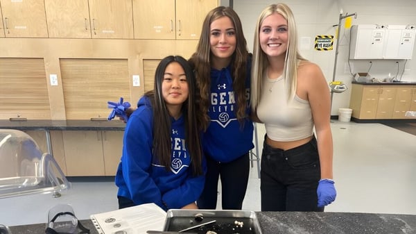 Tres alumnas de la All Saints High School en Calgary están juntas y sonríen en el área de casilleros.