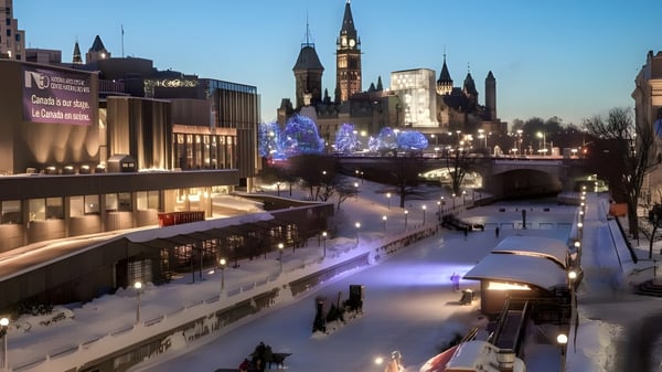 Escena invernal con un canal iluminado y un campanario al fondo cerca de la École secondaire publique L'Alternative.