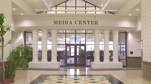 El mediacenter de la American Falls High School muestra una amplia área de entrada con techos altos y columnas.