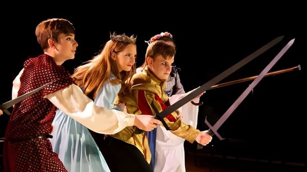 Estudiantes de la American Heritage Academy visten trajes medievales y realizan una obra de teatro con espadas.