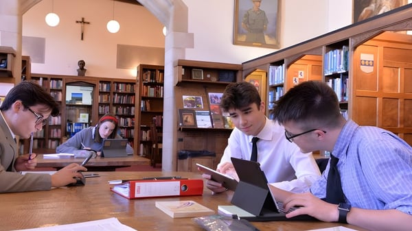 Estudiantes del Ampleforth College aprenden juntos en la biblioteca entre estanterías de libros.
