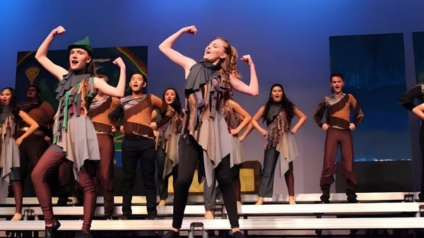 Un grupo de bailarinas y bailarines realiza una actuación de baile en el escenario del Anaheim Union High School District.