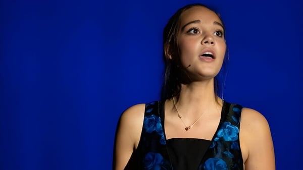 Retrato de una joven con cabello oscuro frente a un fondo azul en el campus de la Andrews Osborne Academy.