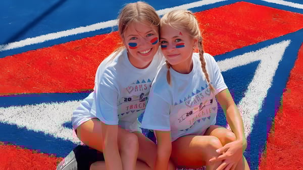 Dos estudiantes de la Arcadia High School posan frente a un fondo rojo-blanco-azul.