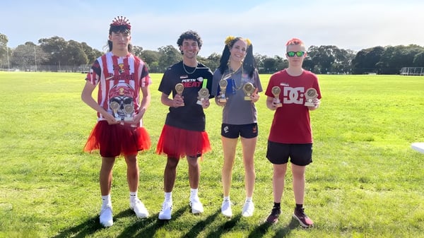 Un grupo de cuatro estudiantes está de pie en un campo en el terreno de la Armadale Senior High School.