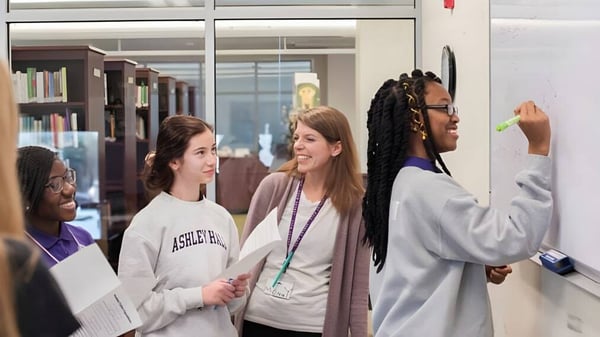Un grupo de estudiantes de la Ashley Hall School está en el pasillo y conversan entre ellos.