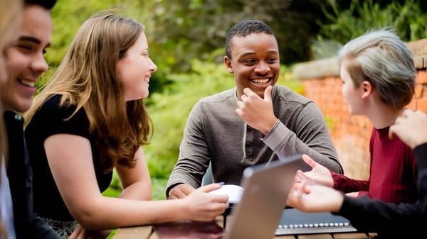 Estudiantes del Ashville College mantienen una animada conversación en el área exterior verde.