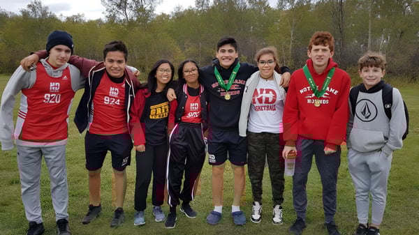 Un grupo de estudiantes está juntos en el bosque del campus del Athol Murray College of Notre Dame.