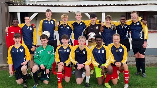 Un grupo de jóvenes futbolistas posan frente a un edificio en el campus del Athy College.