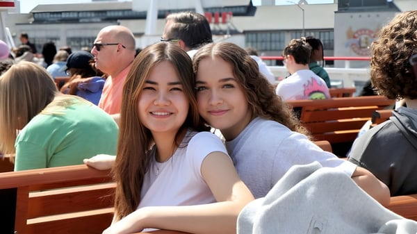 Dos estudiantes de la Auburn Adventist Academy están sentadas juntas en un banco al aire libre.