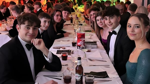 Alumnos de la Austin Friars School en una cena formal en una mesa larga.