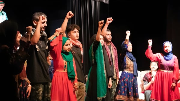 Un grupo de estudiantes de la Balga Senior High School se presenta en un escenario con coloridos trajes tradicionales.