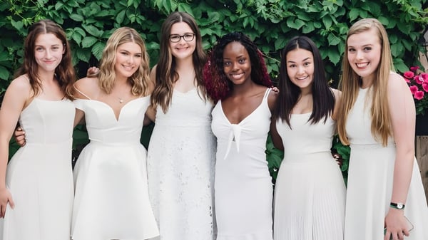 Seis estudiantes de Balmoral Hall High School están frente a una pared de plantas verdes.