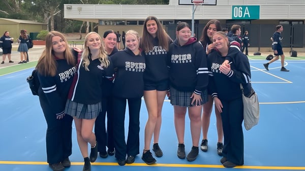 Un grupo de estudiantes está reunido en la cancha de baloncesto de la Banksia Park International High School al aire libre.