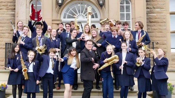 Un grupo de alumnas y alumnos de la Barnard Castle School posan frente a un edificio histórico.
