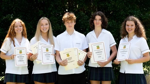 Cinco estudiantes de Barrenjoey High School están con certificados frente a un fondo verde.
