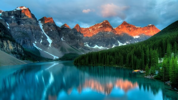 Un lago turquesa con montañas nevadas al fondo, rodeado de bosque, cerca del Barrie North Collegiate Institute.