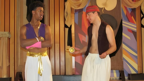 Dos personas están frente a un patrón colorido en el terreno de la Bashaw School.