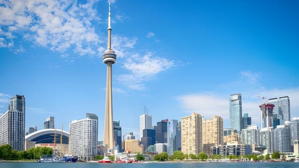La icónica torre se encuentra en primer plano frente al moderno horizonte urbano en el campus de la Bayridge Secondary School.