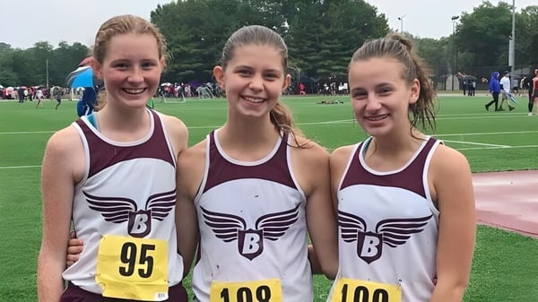 Tres atletas de la Beaver Area High School están juntas en un campo de césped durante una competencia deportiva.