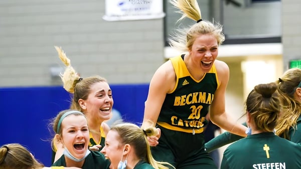 Un grupo de jugadoras de baloncesto de la Beckman Catholic School celebra en la cancha.