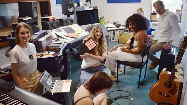 Estudiantes de la Bedales School trabajan juntos en el estudio de música con varios instrumentos musicales y equipos de grabación.