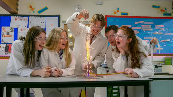 Estudiantes de la Bede's Senior School realizan un experimento con fuego de colores en batas de laboratorio.