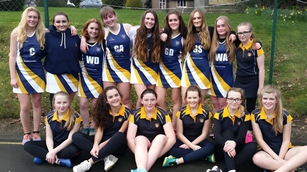 Un grupo de jóvenes jugadoras de netball posan juntas en el campo deportivo de Bedstone College.