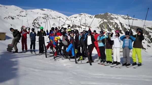 Estudiantes de la Belle River District High School se reúnen para esquiar en una ladera cubierta de nieve.
