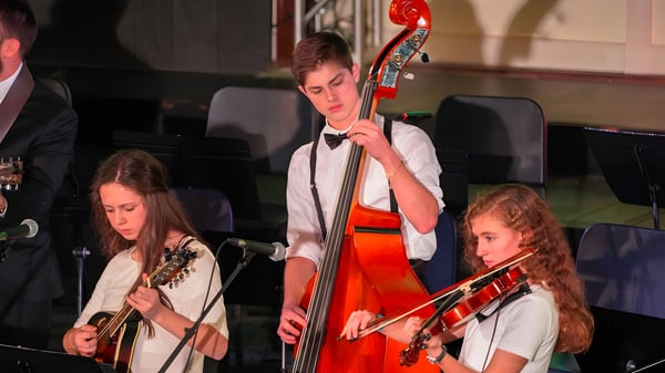 Un grupo de músicos toca en el escenario de la Ben Lippen School en una sala oscura.