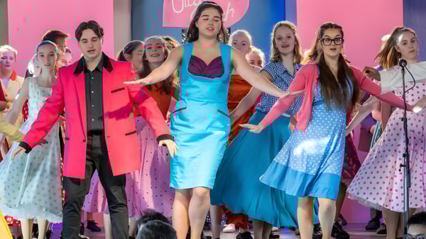 Un grupo de jóvenes mujeres con vestidos coloridos frente a un fondo colorido en la Bethany School.