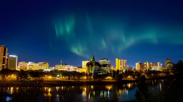 Una toma nocturna con auroras boreales sobre la ciudad, que se reflejan en un agua tranquila, sin relación directa con la Bethlehem High School.