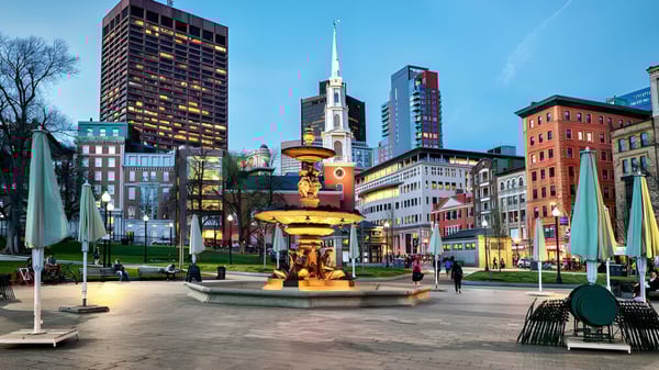 Las personas pasean por la plaza concurrida frente al horizonte de la ciudad cerca de la Beverly High School.