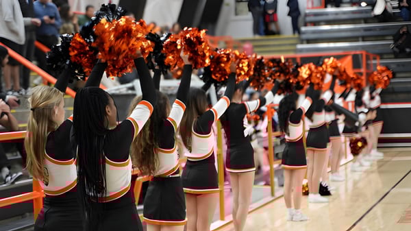 Los trajes de animadoras de la Beverly High School con pompones están listos en una arena deportiva.