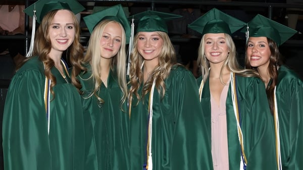 Cinco estudiantes de la Billings Central Catholic High School celebran juntas su graduación en togas verdes.