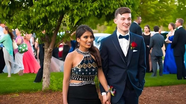 Una joven pareja vestida de manera formal está en un evento en el área exterior de la Bishop Brady High School.