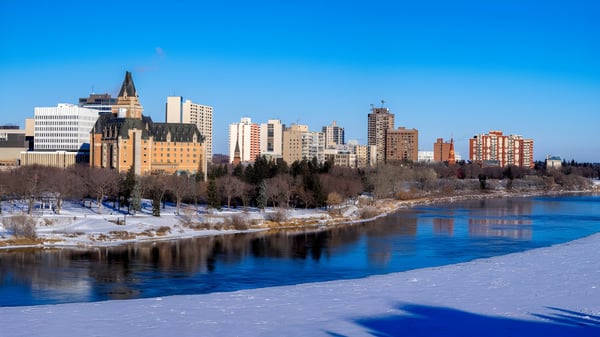Un río congelado fluye a través de la ciudad con altos edificios y una estructura similar a una catedral al fondo cerca de la Bishop Mahoney High School.