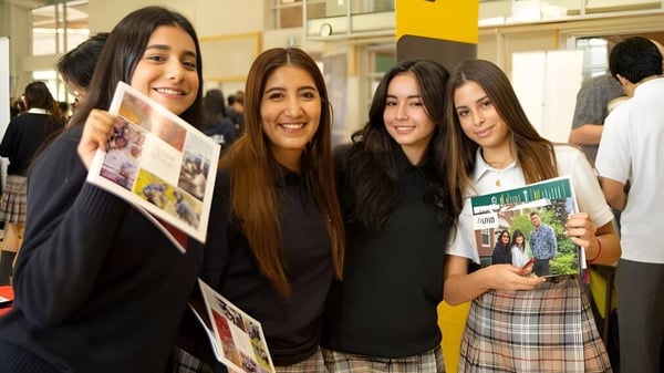 Cuatro estudiantes de la Bodwell High School sonríen y posan juntas en un aula.