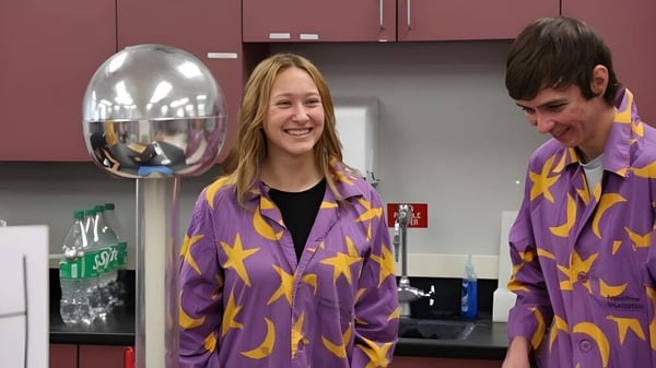 Dos personas con chaquetas estrelladas están en una sala con varios objetos en el Boise School District.