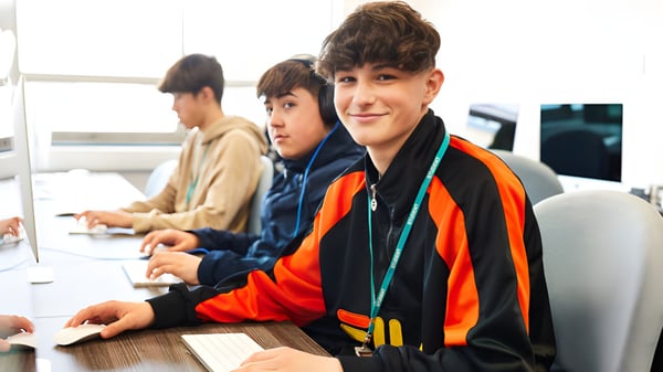 Estudiantes del Boston College trabajan juntos en computadoras durante una actividad educativa.